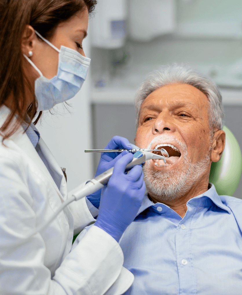 Family dentist explaining dental procedure to a senior patient